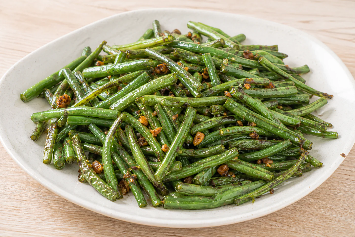 Cut white long beans stir-fried with browned garlic and savory aromatics.